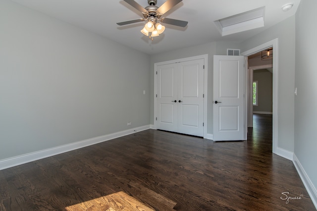 unfurnished bedroom featuring dark hardwood / wood-style floors, ceiling fan, and a closet