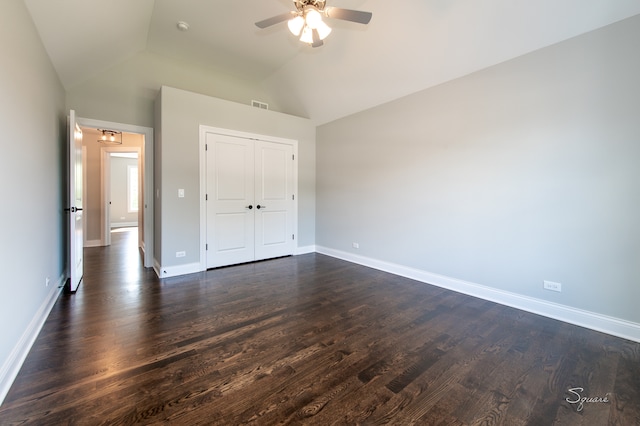 unfurnished bedroom featuring lofted ceiling, dark hardwood / wood-style flooring, ceiling fan, and a closet