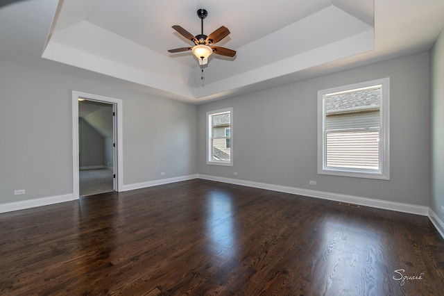 spare room with a healthy amount of sunlight, dark hardwood / wood-style floors, and ceiling fan