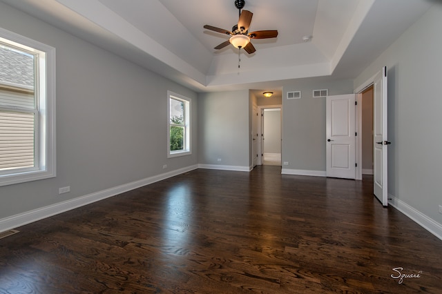 spare room featuring a tray ceiling, dark hardwood / wood-style flooring, and ceiling fan