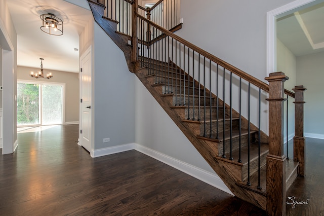 stairway featuring wood-type flooring and an inviting chandelier