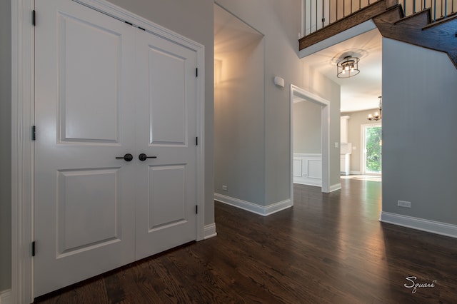 hall with an inviting chandelier and dark wood-type flooring