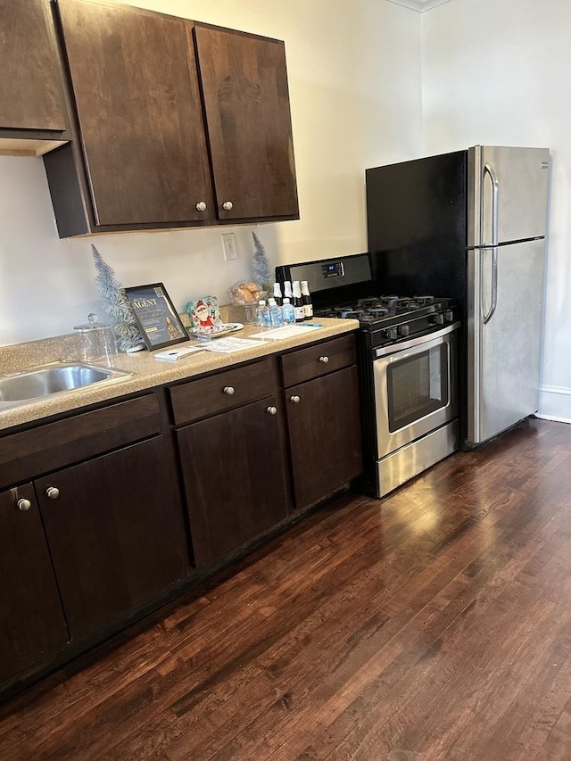 kitchen with dark brown cabinets, stainless steel appliances, dark hardwood / wood-style floors, and sink