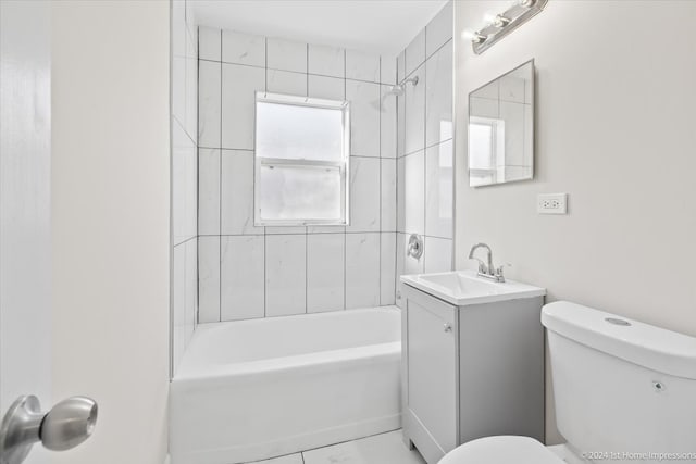 full bathroom with tiled shower / bath, vanity, and toilet