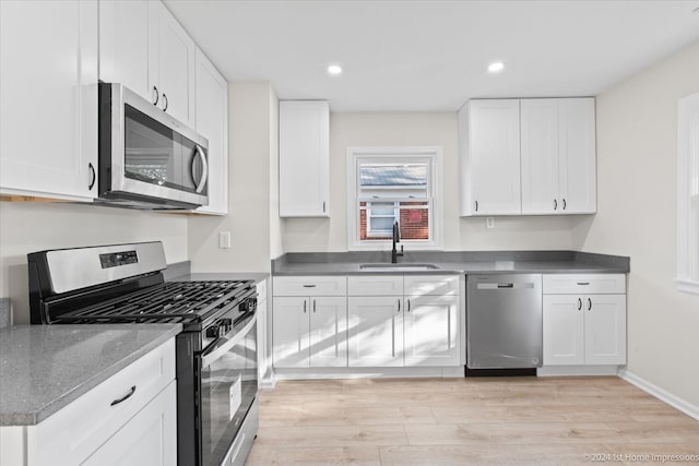 kitchen featuring appliances with stainless steel finishes, light hardwood / wood-style floors, and white cabinetry