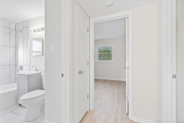 full bathroom featuring hardwood / wood-style floors, vanity, toilet, and tiled shower / bath