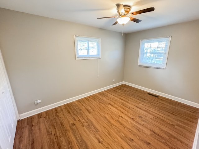 unfurnished room with hardwood / wood-style floors, plenty of natural light, and ceiling fan