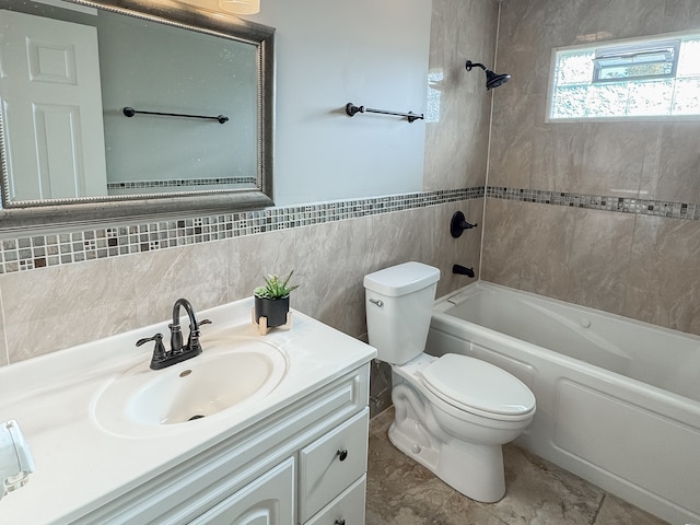 full bathroom with tiled shower / bath combo, tile patterned floors, toilet, vanity, and tile walls