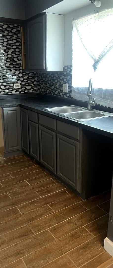 1249 Cunningham Dr Unit 3E, Calumet City, IL 60409 - kitchen featuring dark wood finished floors, dark countertops, a sink, backsplash, and gray cabinetry