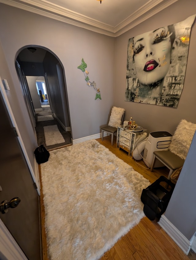 sitting room with ornamental molding and hardwood / wood-style floors