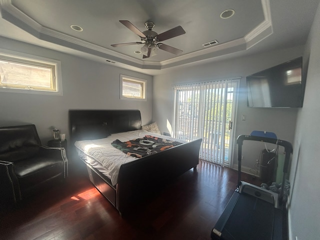 bedroom with ceiling fan, access to outside, a tray ceiling, dark hardwood / wood-style floors, and crown molding