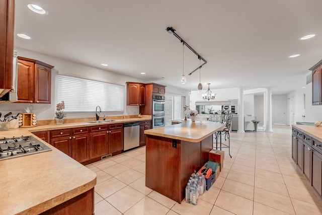 kitchen featuring sink, a center island, a kitchen breakfast bar, stainless steel appliances, and an inviting chandelier