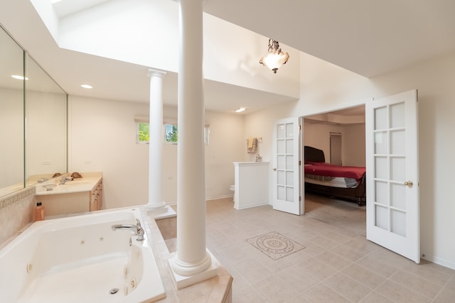 bathroom with toilet, vanity, french doors, tile patterned floors, and tiled bath