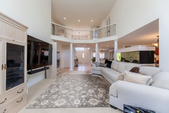 living room with light carpet, a high ceiling, and decorative columns