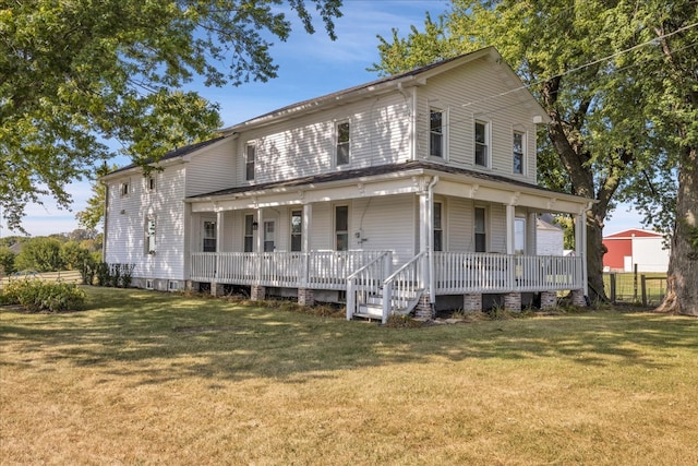 rear view of house featuring a lawn and covered porch