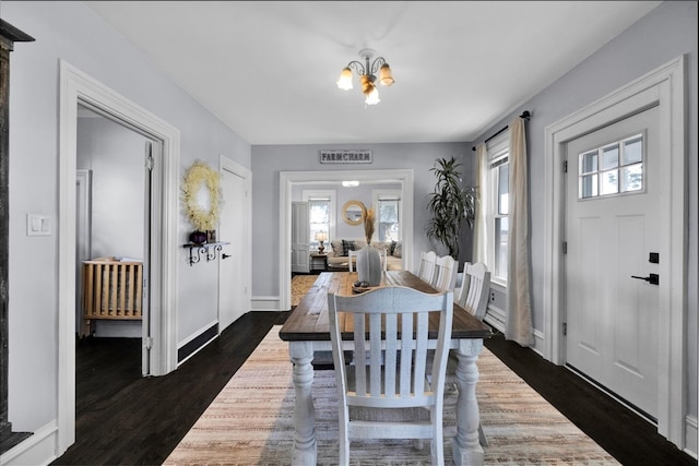 dining area featuring dark hardwood / wood-style floors and a chandelier