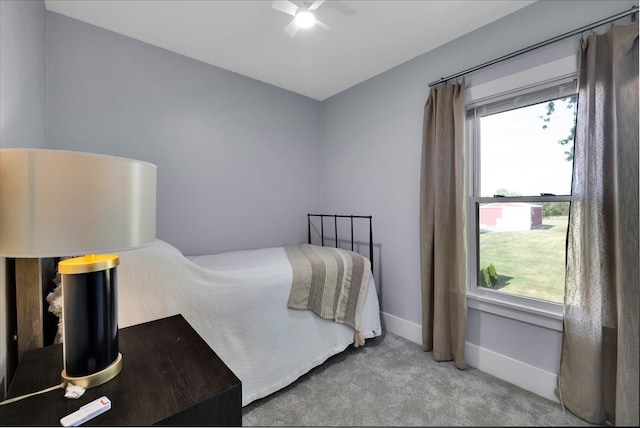 bedroom featuring multiple windows, ceiling fan, and light colored carpet