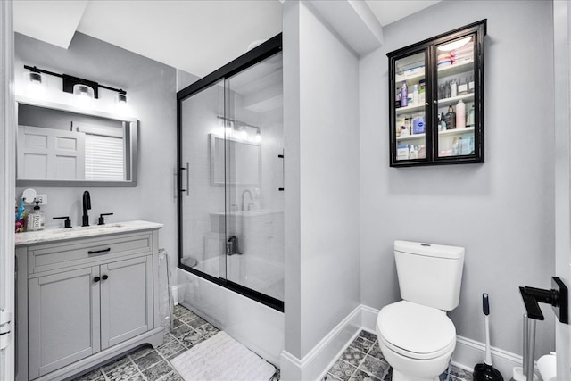 full bathroom with vanity, toilet, and bath / shower combo with glass door