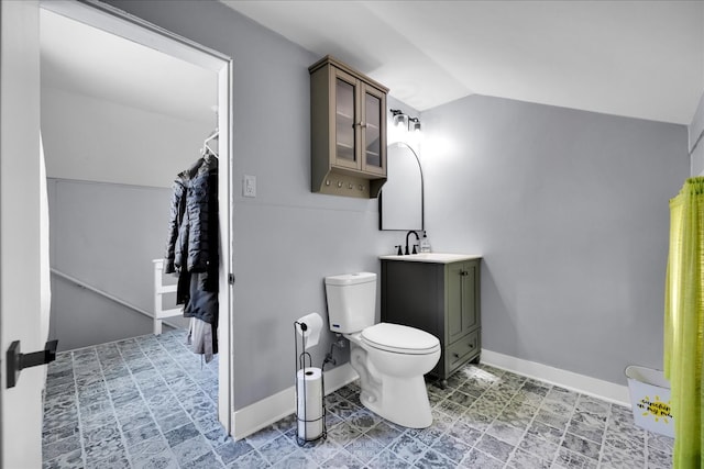 bathroom featuring vaulted ceiling, vanity, and toilet