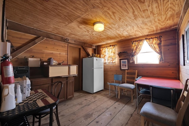 kitchen featuring wood walls, light hardwood / wood-style floors, wooden ceiling, and white fridge