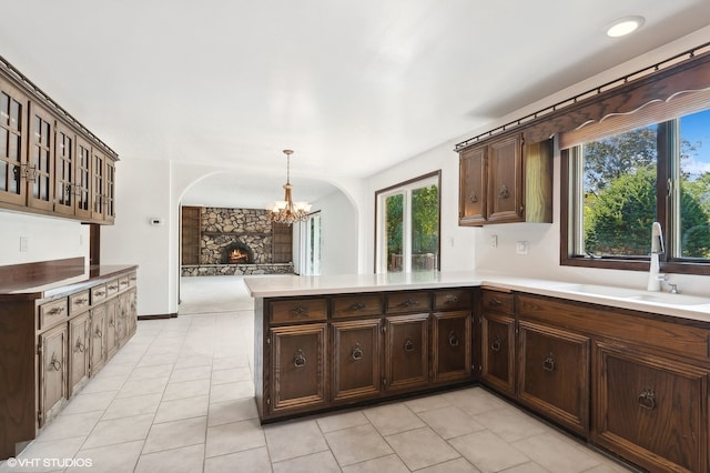 kitchen with an inviting chandelier, kitchen peninsula, plenty of natural light, and sink