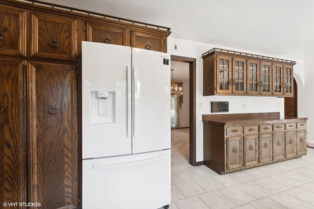 kitchen with white refrigerator with ice dispenser and light tile patterned flooring