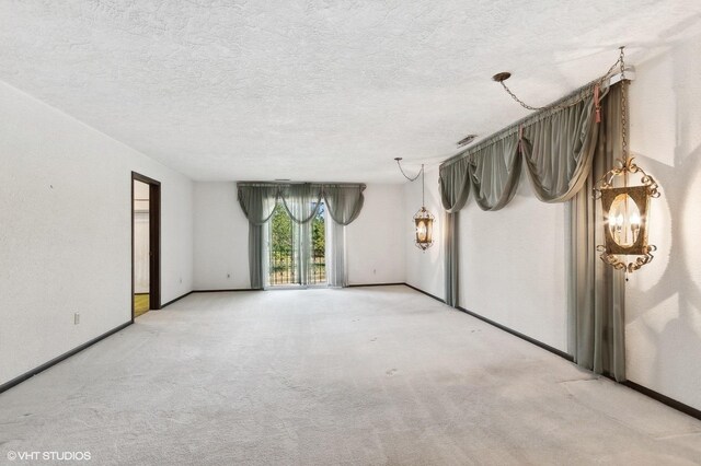 carpeted spare room featuring a textured ceiling