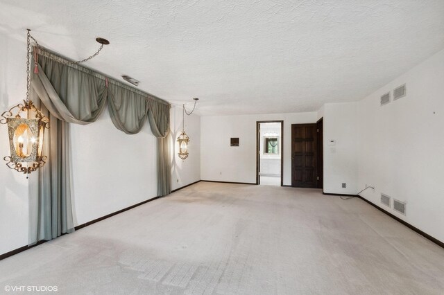 carpeted spare room featuring a textured ceiling