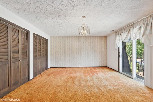 interior space with access to outside, an inviting chandelier, two closets, and light carpet