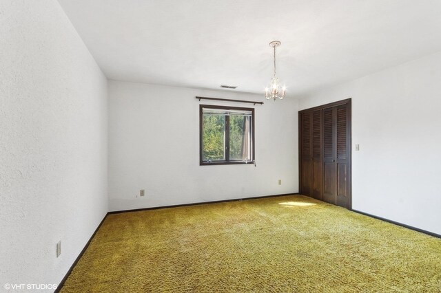 unfurnished room featuring carpet floors and a notable chandelier