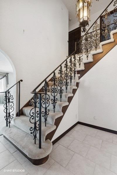 stairs with a towering ceiling and tile patterned floors