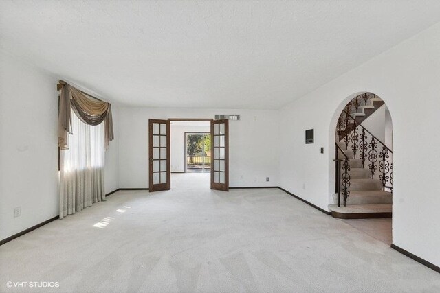 unfurnished room featuring light colored carpet and french doors