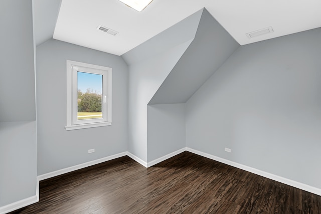 additional living space with vaulted ceiling and dark hardwood / wood-style floors