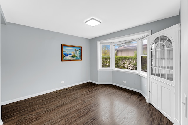 unfurnished room with dark wood-type flooring