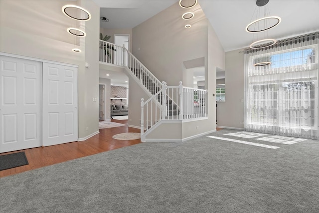 entrance foyer featuring wood-type flooring and high vaulted ceiling