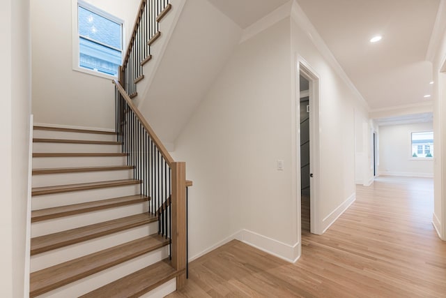 stairs featuring crown molding and hardwood / wood-style flooring