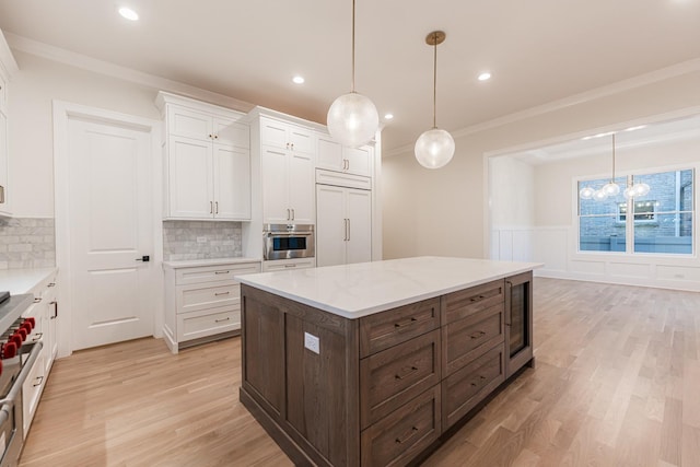 kitchen featuring white cabinetry, tasteful backsplash, decorative light fixtures, paneled built in refrigerator, and oven