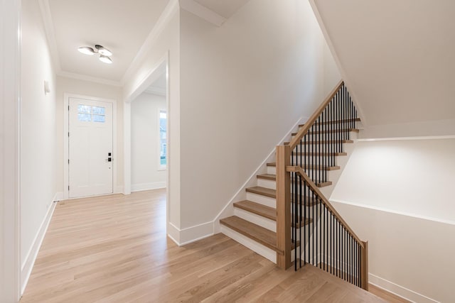 foyer featuring ornamental molding and light wood-type flooring