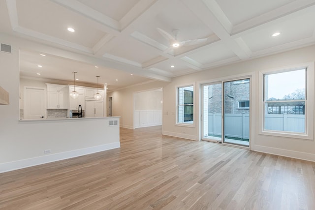 unfurnished living room featuring coffered ceiling, beamed ceiling, and light wood-type flooring