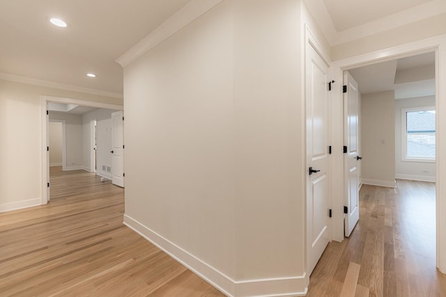 hallway with crown molding and light wood-type flooring