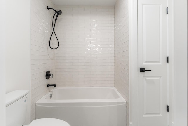 bathroom featuring tiled shower / bath and toilet