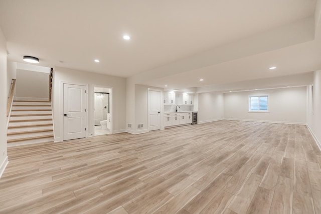 basement featuring sink and light wood-type flooring