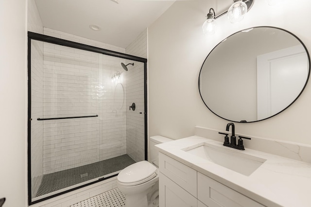 bathroom with vanity, toilet, and a shower with door