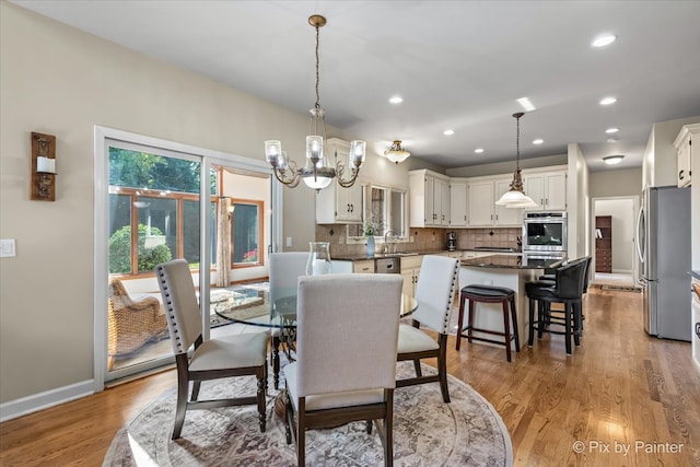 dining area with a chandelier, sink, and wood-type flooring