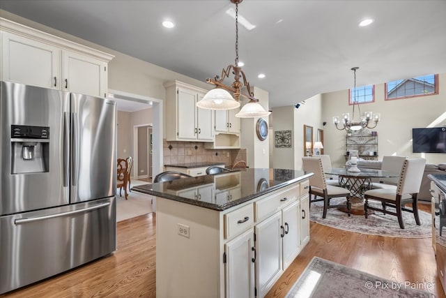 kitchen featuring pendant lighting, light hardwood / wood-style flooring, stainless steel fridge, a kitchen island, and white cabinetry