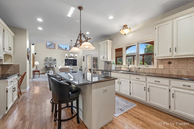 kitchen with pendant lighting, tasteful backsplash, light hardwood / wood-style flooring, and sink