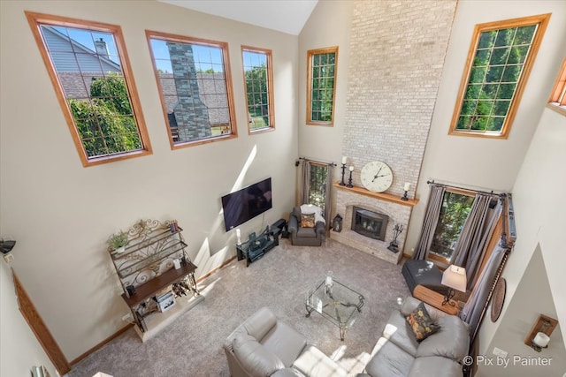 living room with carpet flooring, a large fireplace, and a towering ceiling