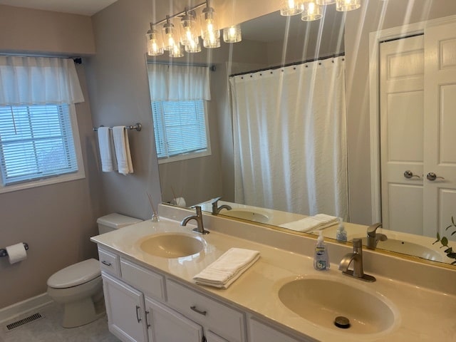 bathroom with tile patterned flooring, vanity, and toilet