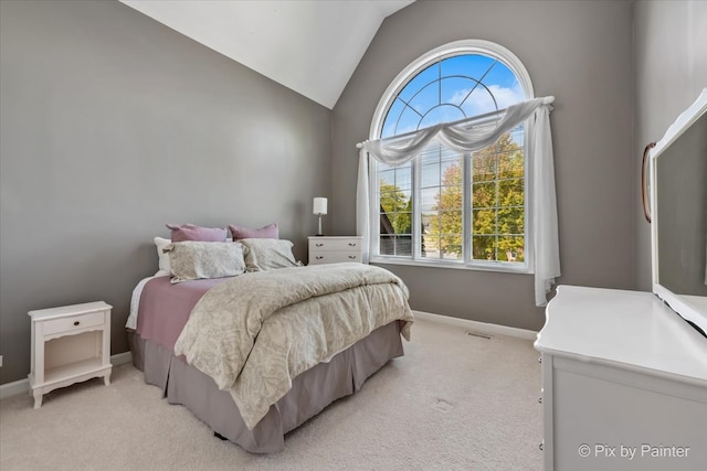 bedroom featuring light colored carpet and lofted ceiling