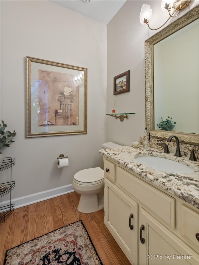 bathroom with hardwood / wood-style floors, vanity, and toilet